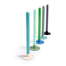 Set of colorful candles in stands on a white background