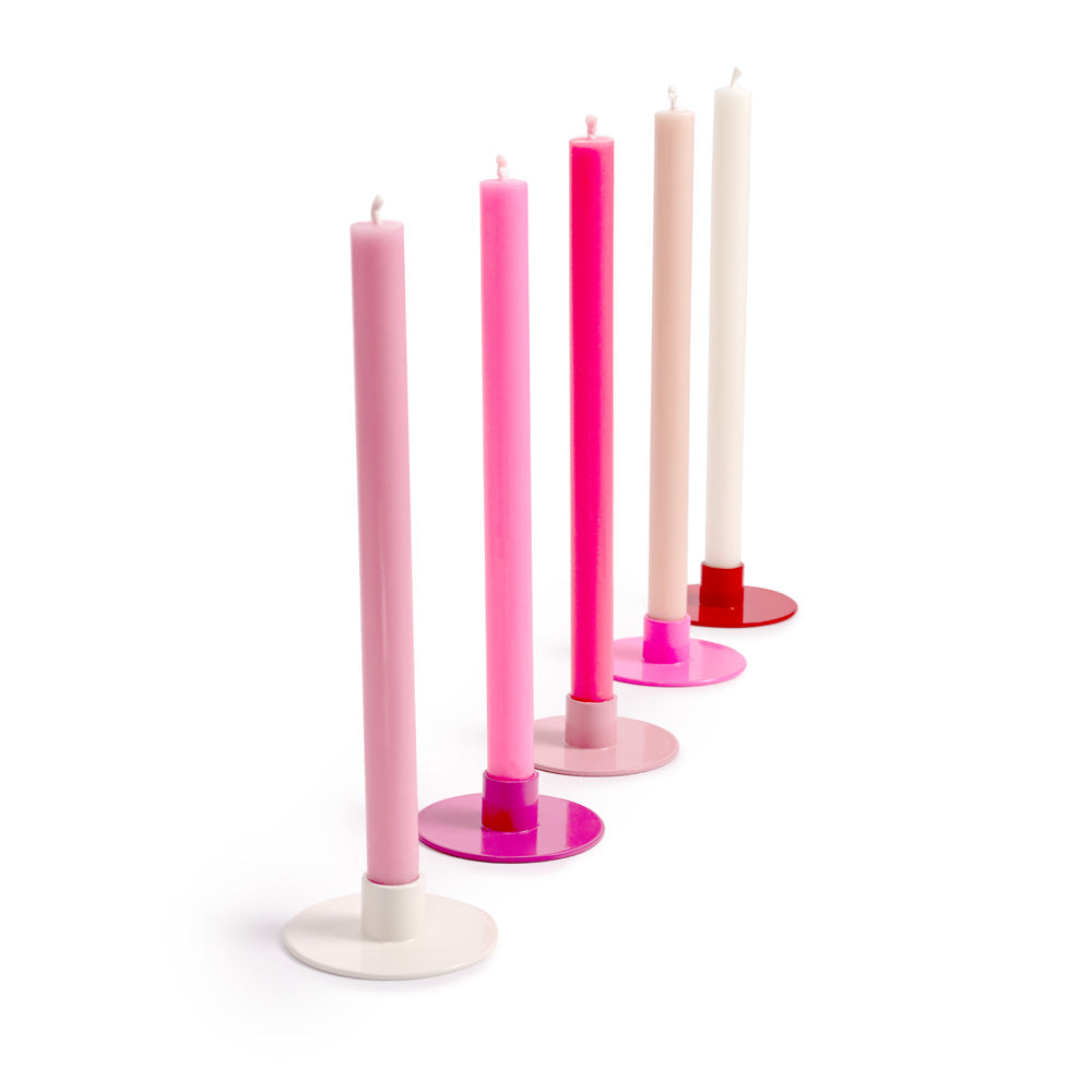 Set of colorful candles on stands against a white background