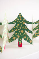 Decorative paper Christmas trees with gold accents on a white background