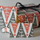 Set of Christmas-themed gift tags with red, black, and white patterns on a gray background.