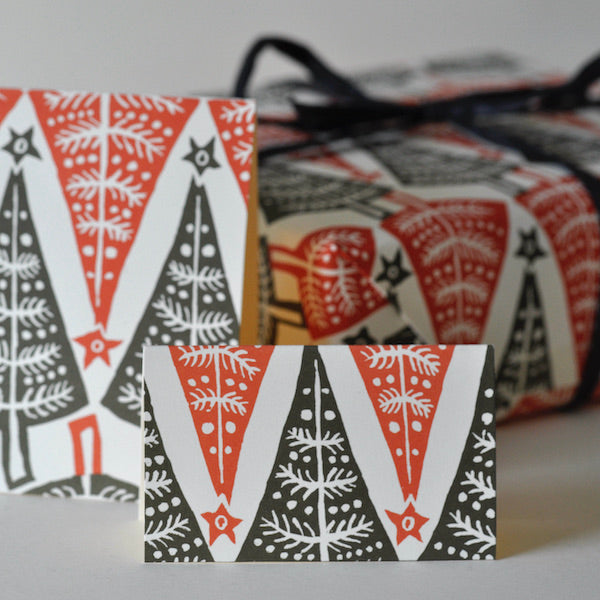 Set of Christmas-themed gift tags with red, black, and white patterns on a gray background.