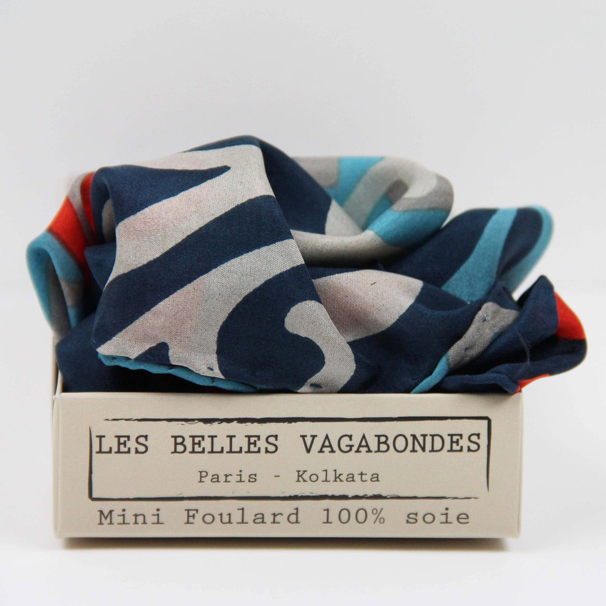 Colorful scarf in a box with 'Les Belles Vagabondes' branding on a white background