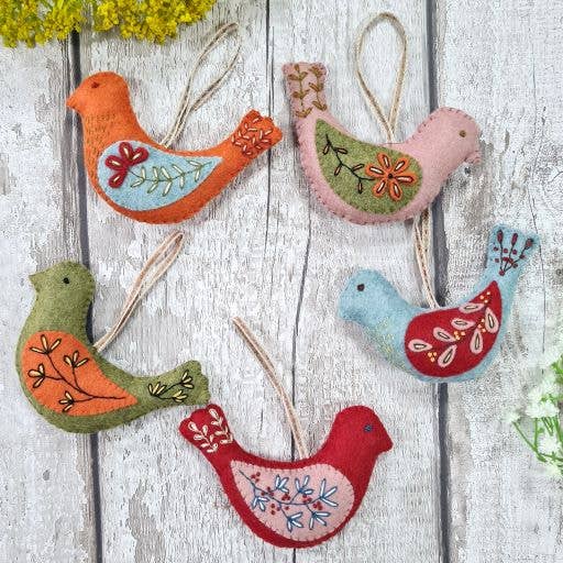 Colorful bird-shaped decorations on a wooden surface