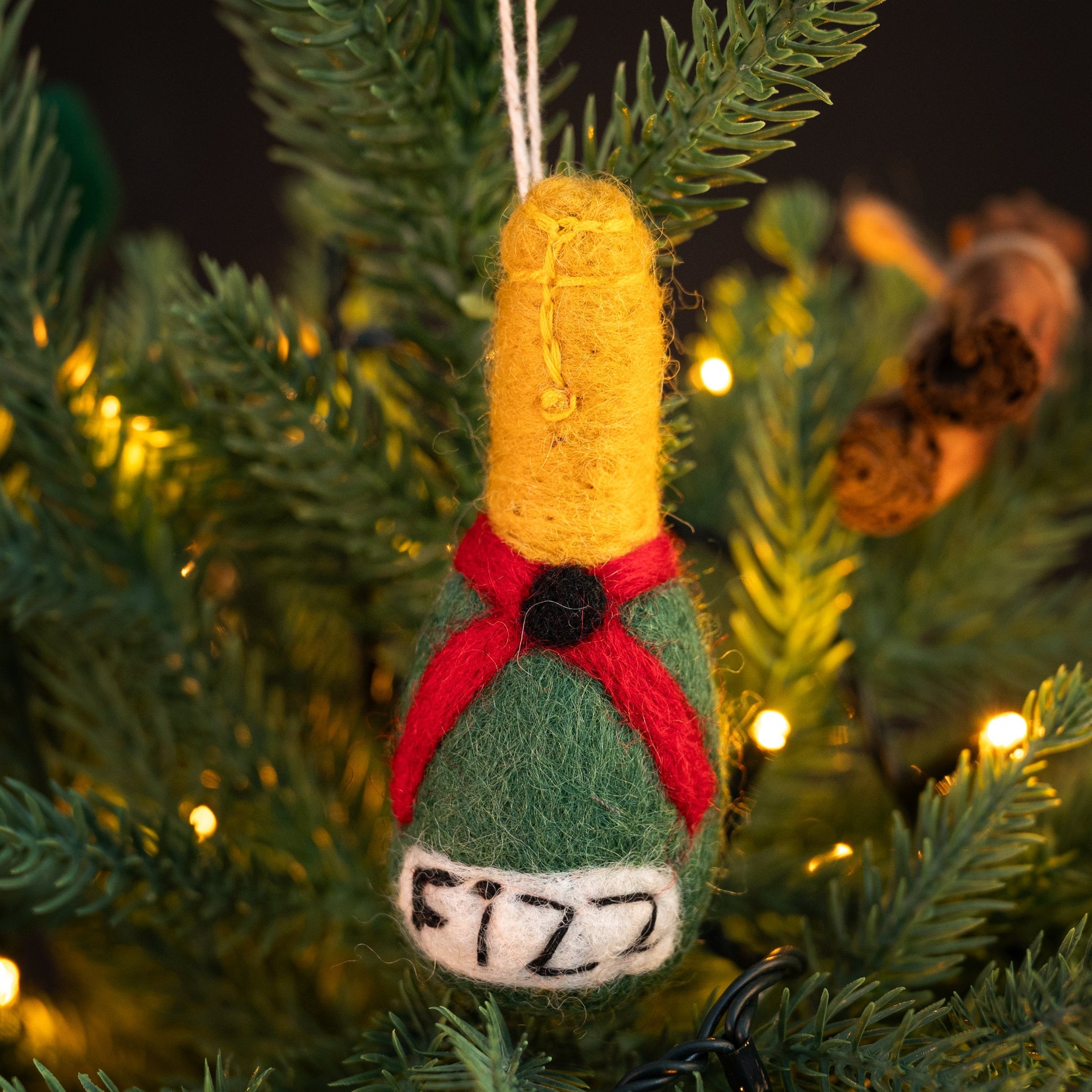 Felted wine bottle ornament with 'BUBBLES' text on a Christmas tree.