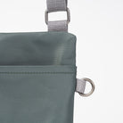 Close-up of a green bag with gray straps on a white background