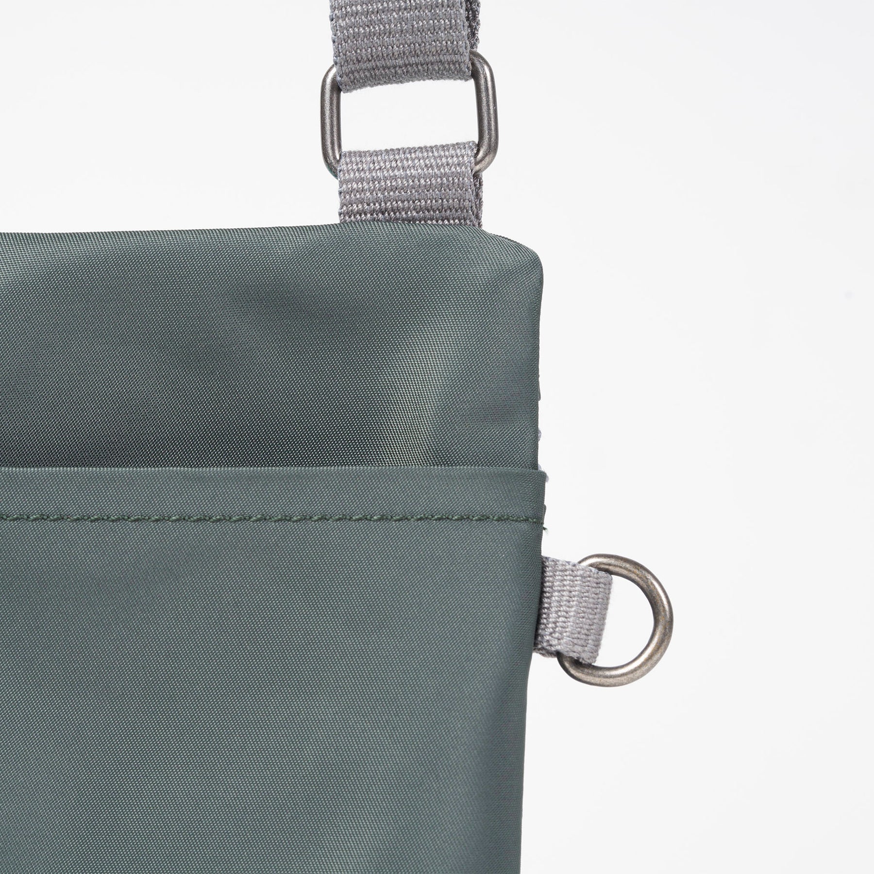 Close-up of a green bag with gray straps on a white background