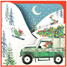 Christmas card with a green truck carrying a Christmas tree, a dog on skis, and a dog on a snowmobile.