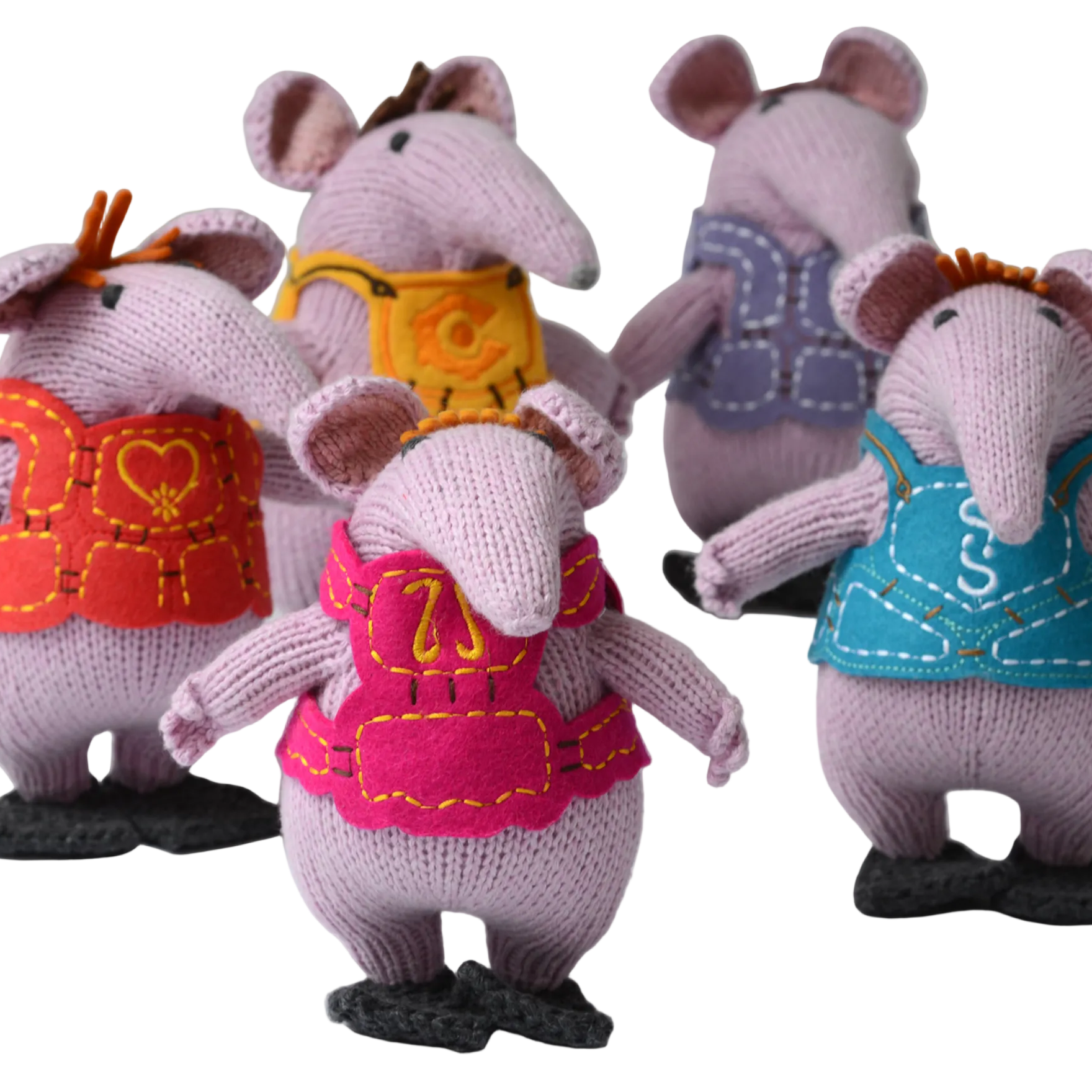 Five knitted mouse plush toys standing side by side, each wearing a different coloured vest. The vests are orange-red, yellow, pink, and blue, and the mice are made of light purple-pink knit fabric.