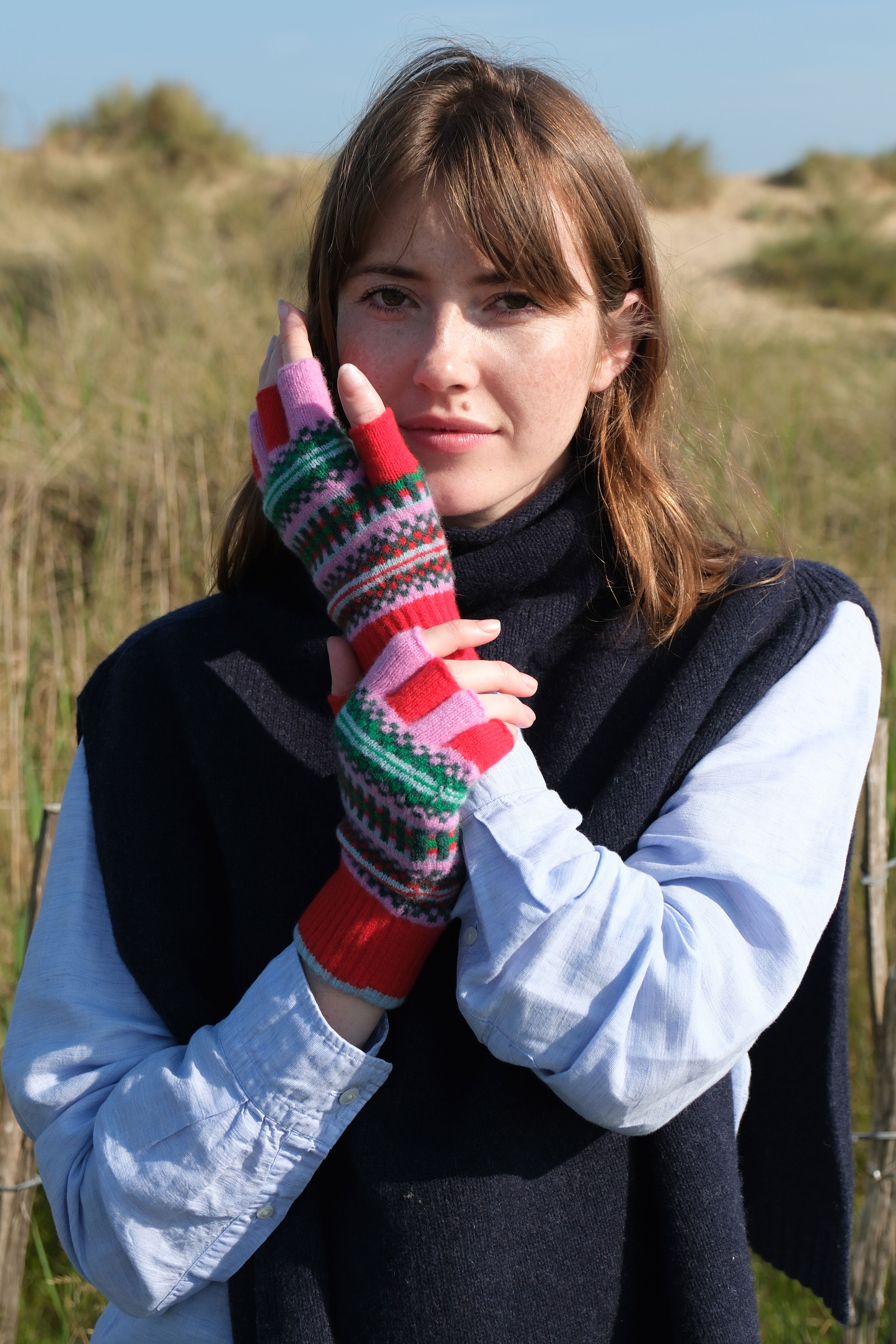 Woman wearing colorful fingerless gloves in a natural setting
