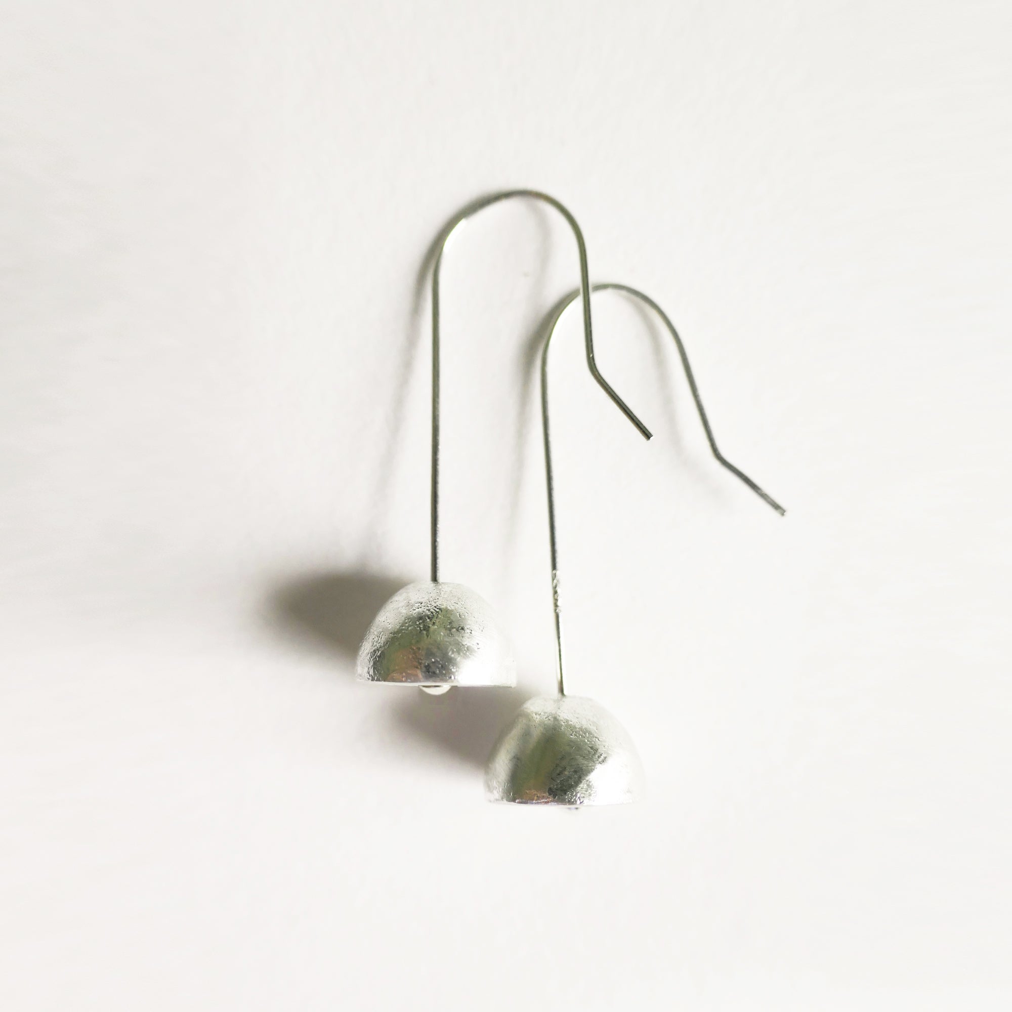 Pair of silver earrings dome shaped on a  stone on a white background