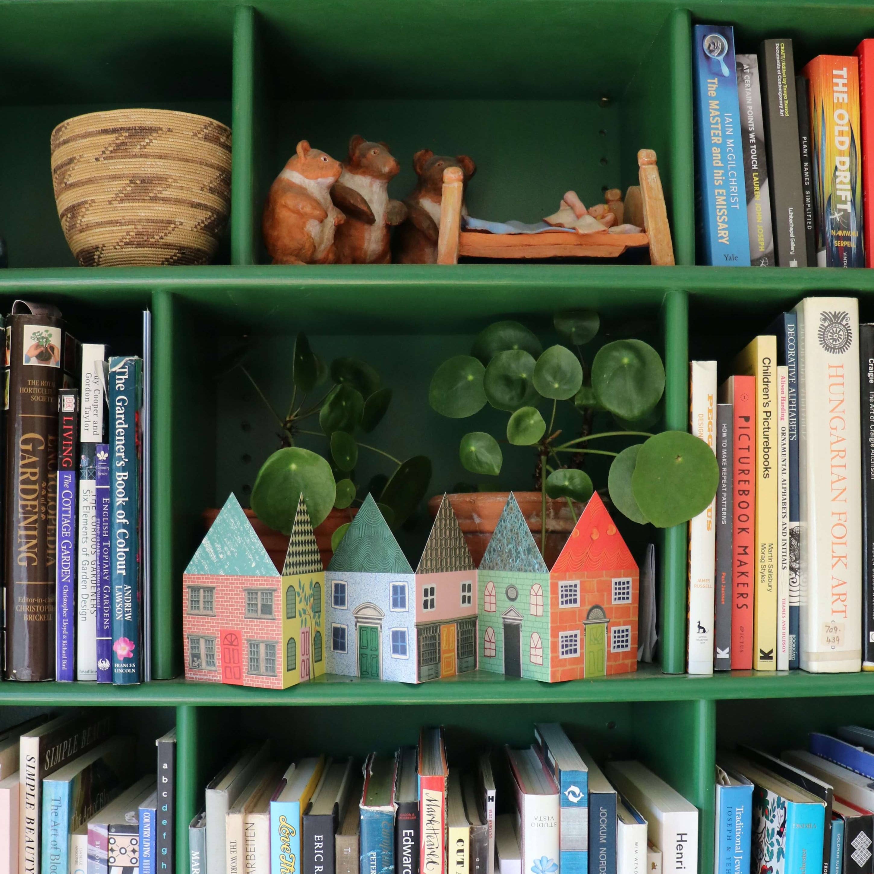 Bookshelf with books and decorative items on display including the houses concertina card
