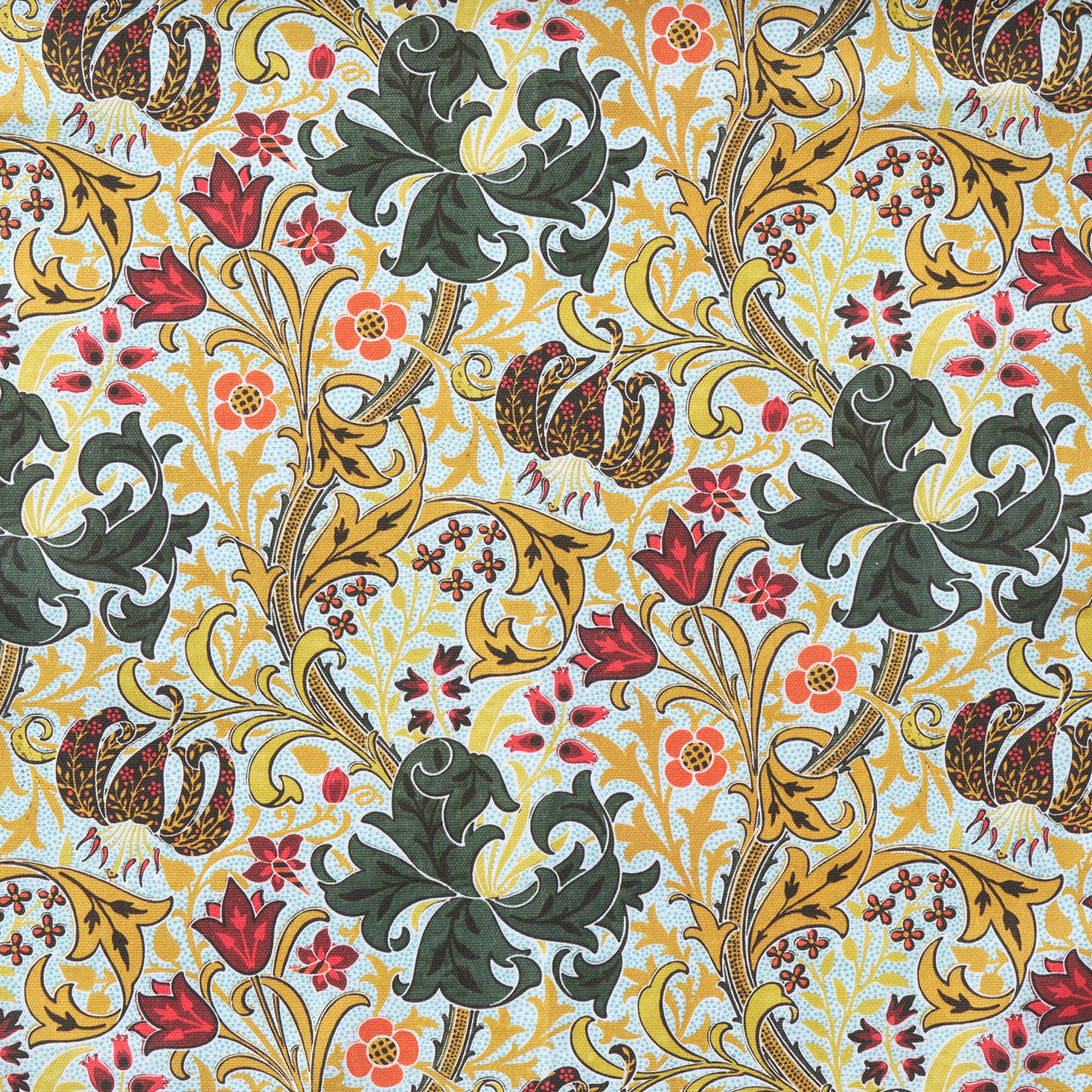 Decorative fabric with intricate floral and leaf patterns in green, gold, red, and orange on a light blue background.