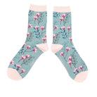 Floral patterned socks with pink accents on a light blue background