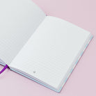 Open notebook with lined pages on a pink background