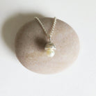 Pearl necklace on a stone with a white background