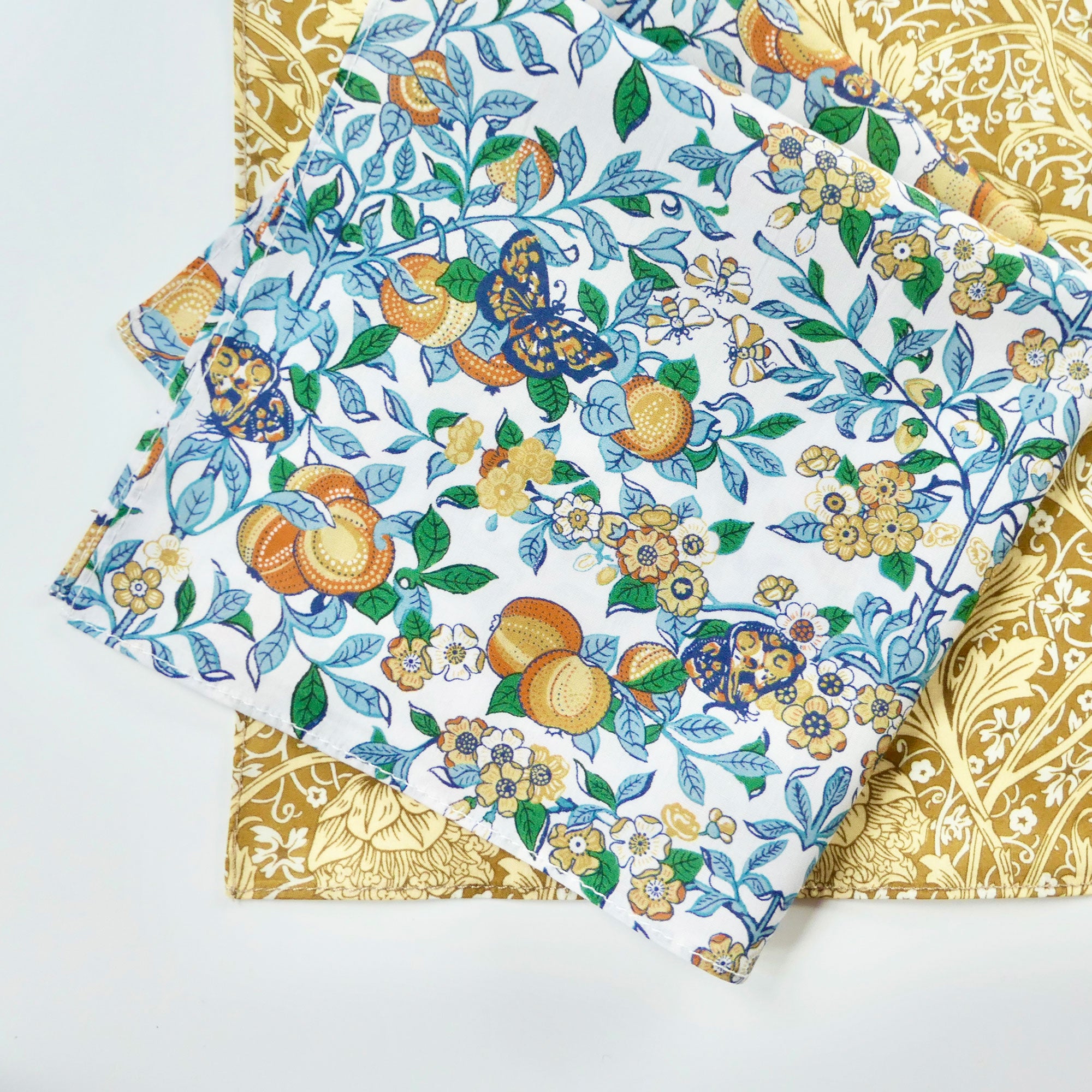 Decorative fabric hankies with floral and fruit pattern on a white background