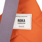 Roka London label on an orange fabric background