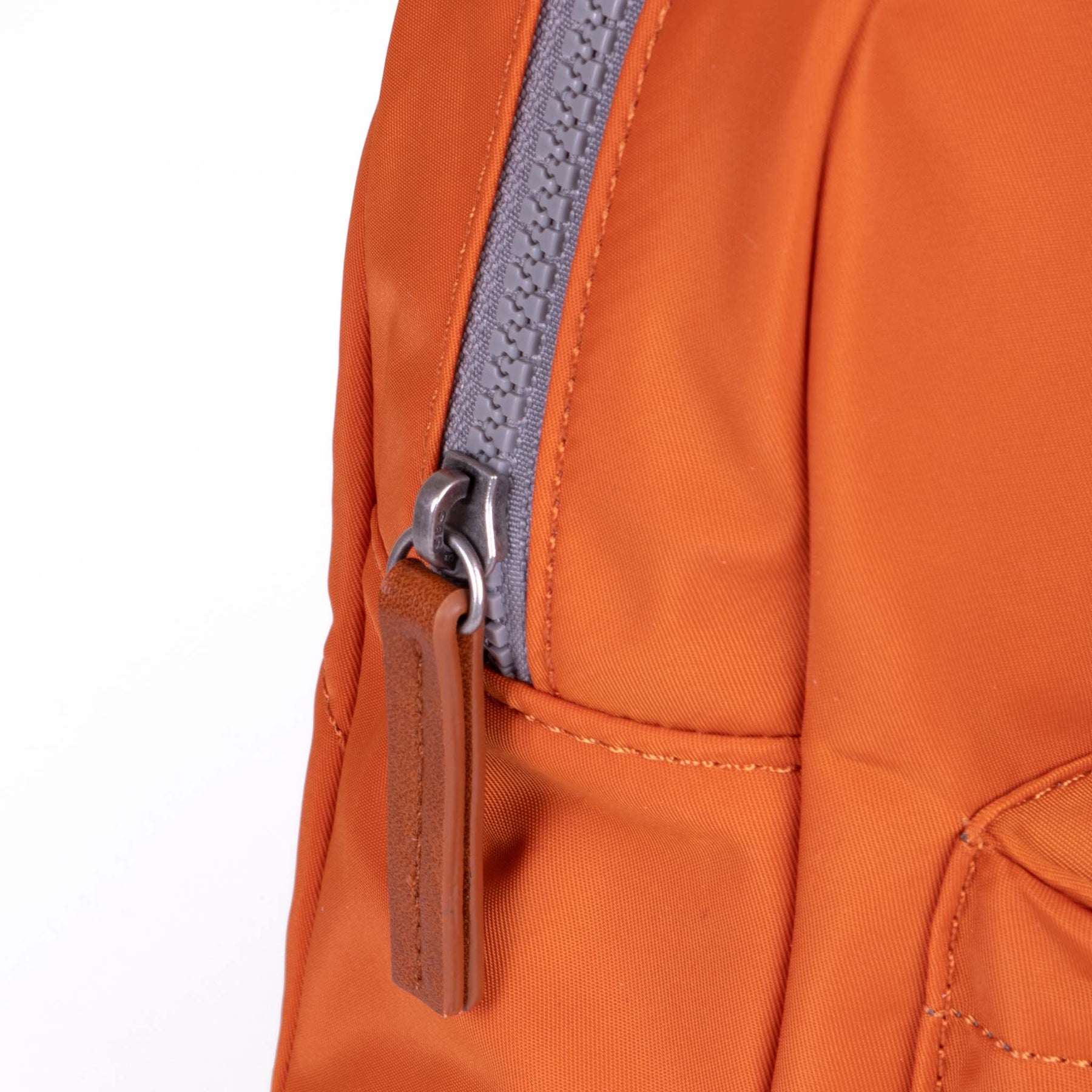 Close-up of an orange backpack with a zipper