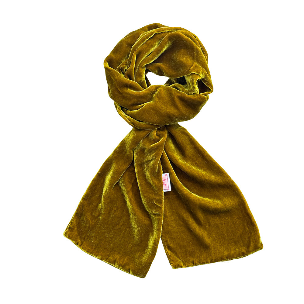 A mustard yellow velvet scarf, styled in a loose knot, displayed against a solid white background.