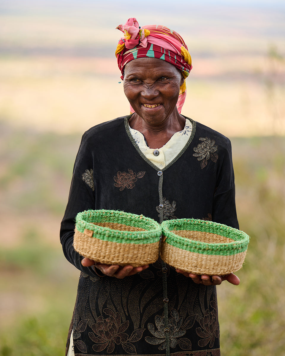 Woman holding two woven baskets outdoors