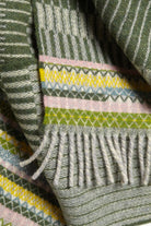 Close-up of a patterned fabric with green, pink, and yellow colors.