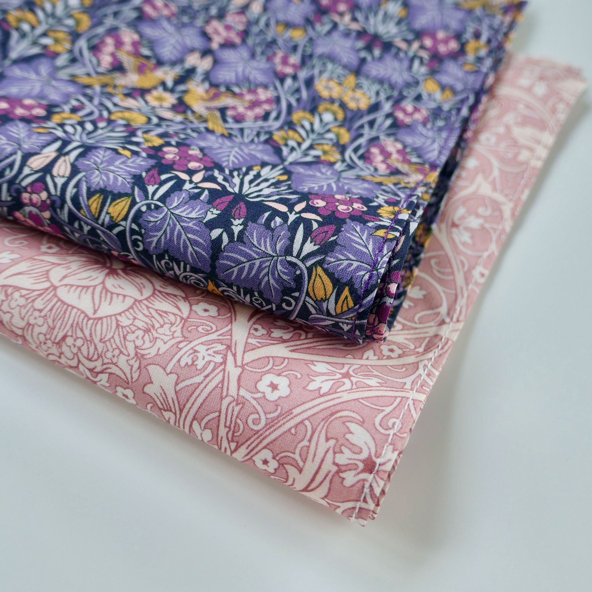 Two fabric hankies with floral patterns on a light background