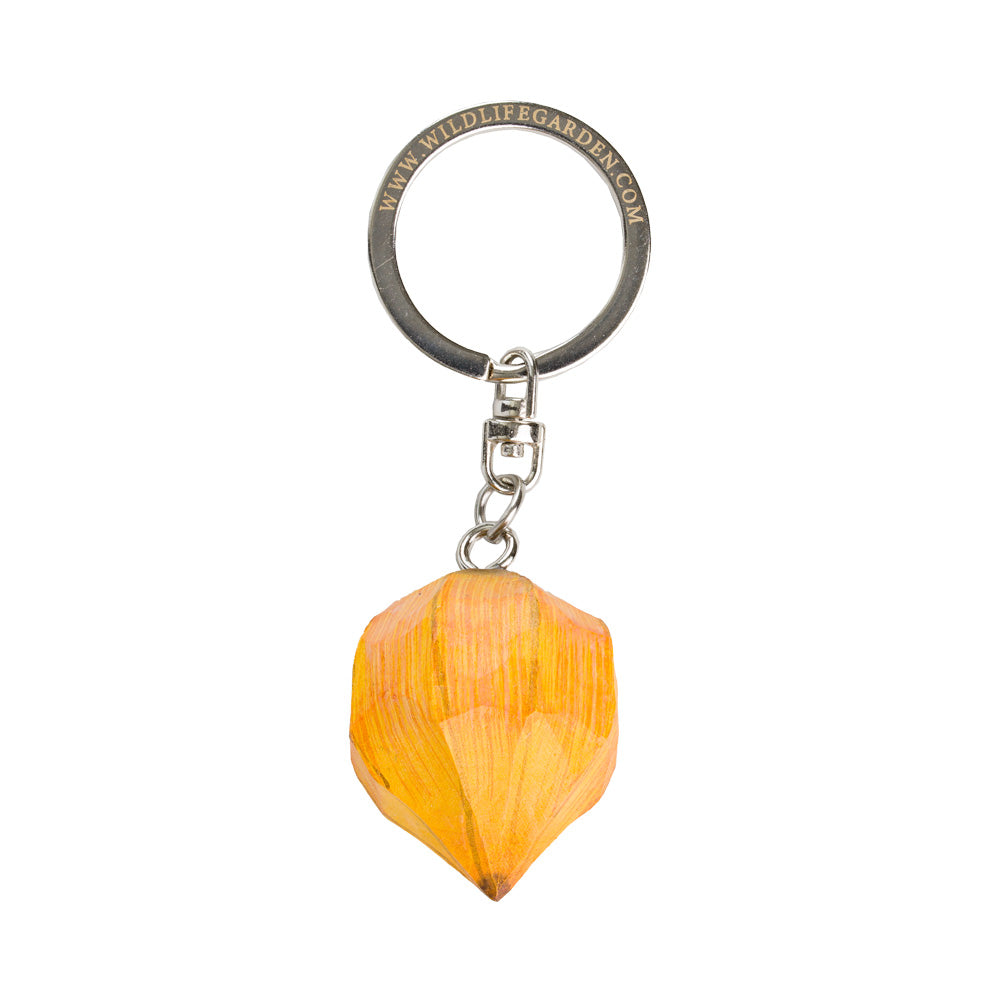 A keychain featuring a carved orange wood pendant shaped like a stylized flower bud, attached to a silver metal split ring engraved