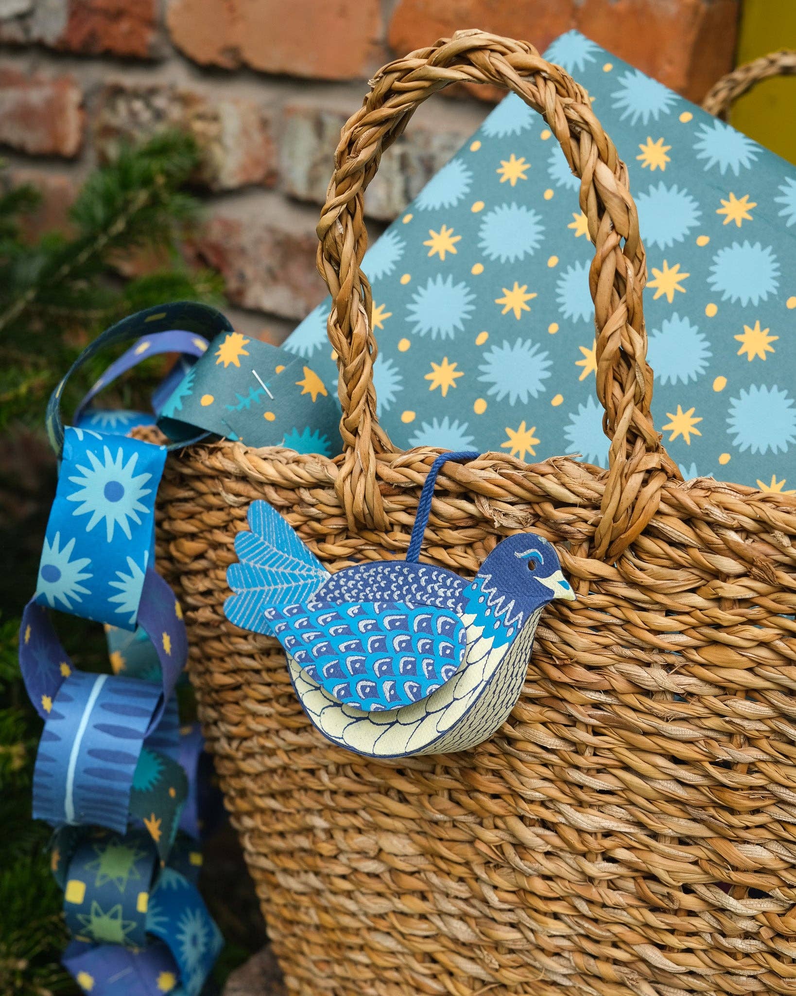 Wicker basket with a blue decorative bird tag against a patterned fabric background