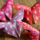 Colorful paper bows with polka dots on a wooden surface