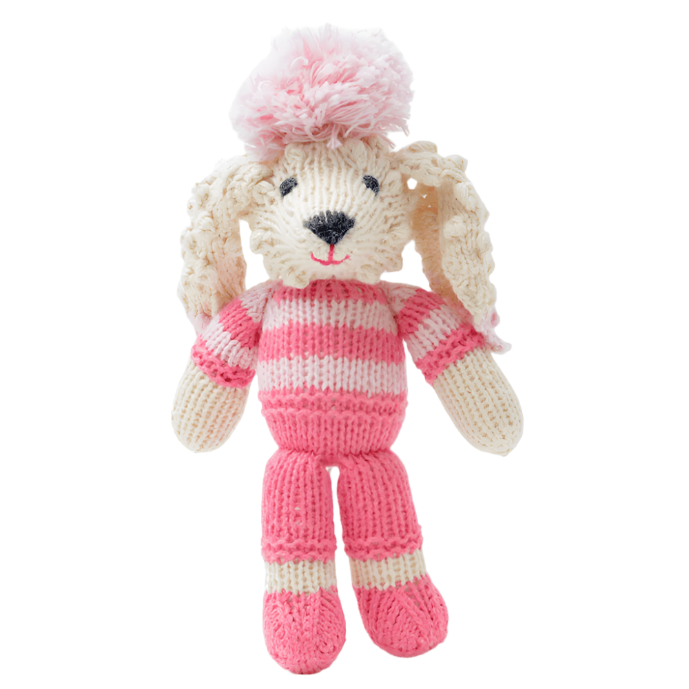 Knitted toy dog in a pink outfit and hat on a white background