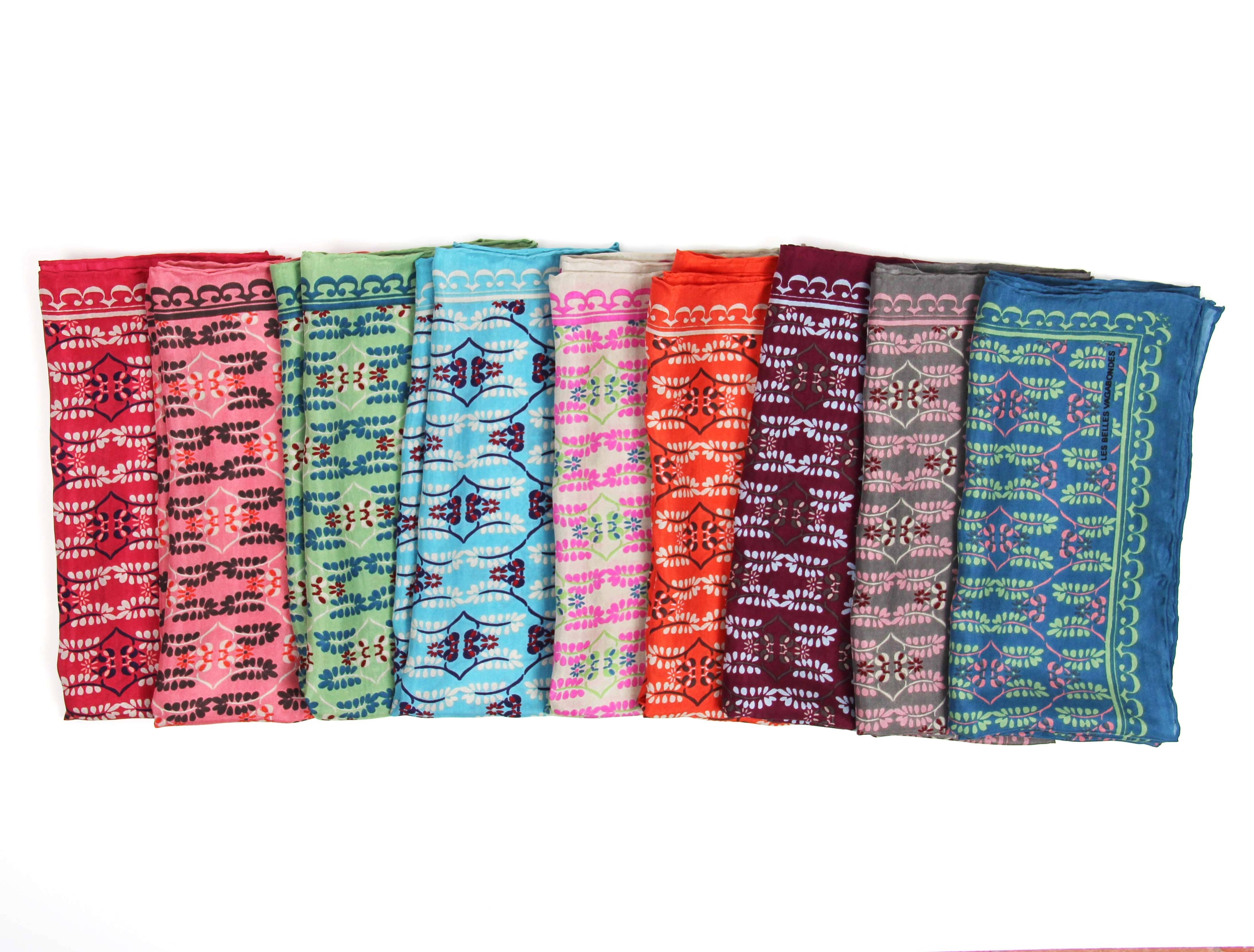 Set of colorful patterned scarves arranged in a row on a white background