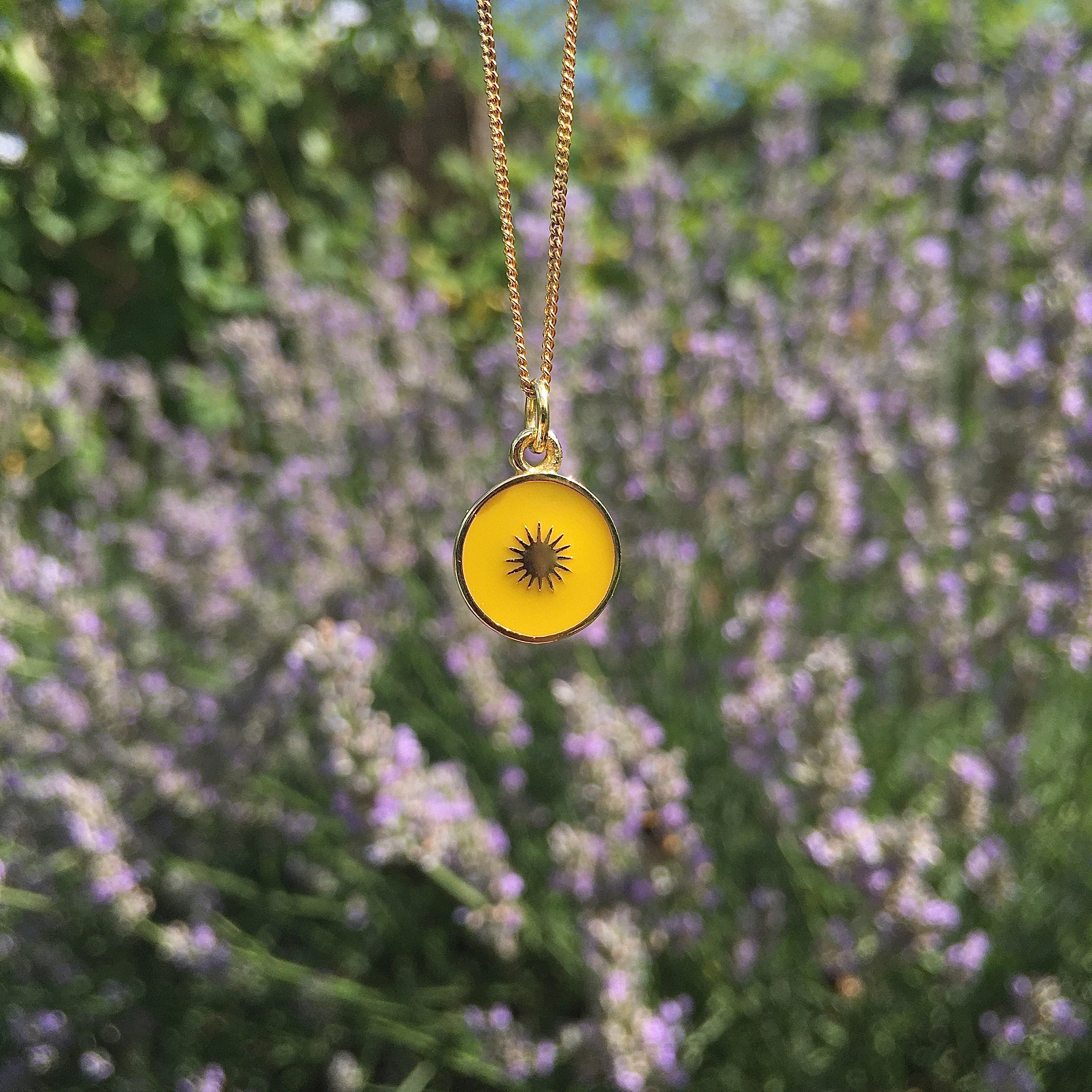 yellow enamel pendant in sun motif
