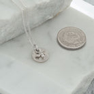 mini bee necklace next to coin for size