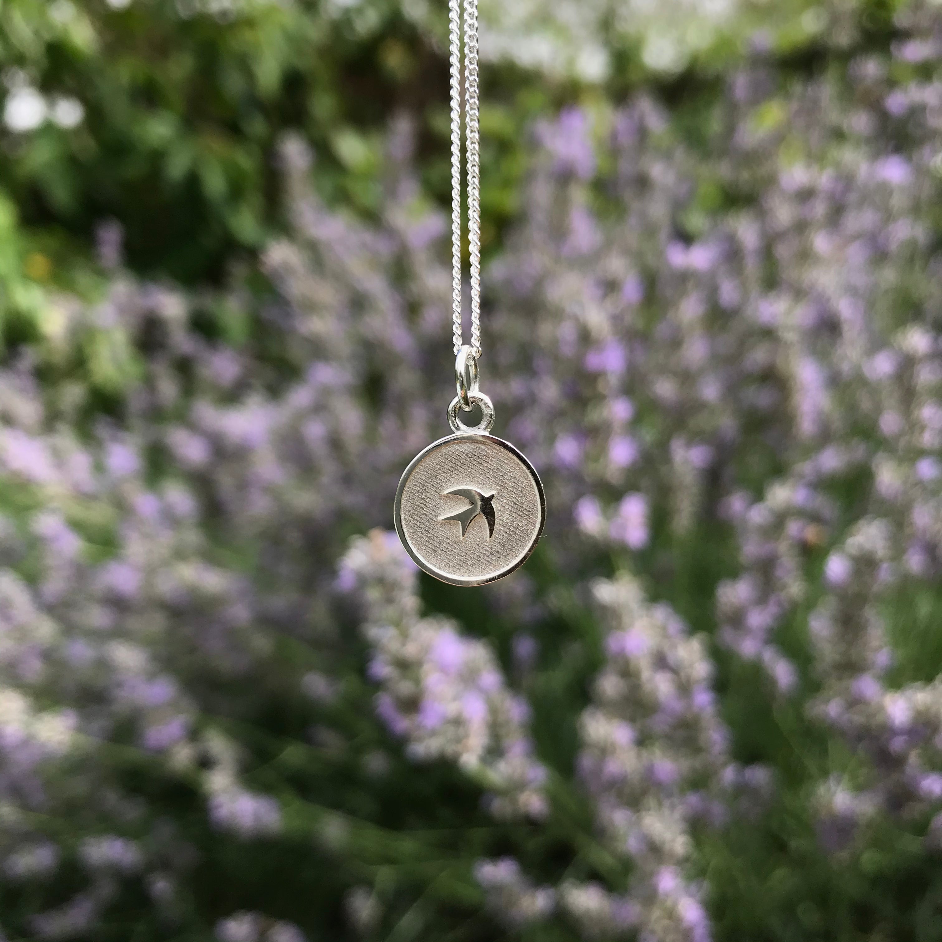 silver medallion with swallow insert design