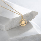 gold vermeil supernova token necklace on marble