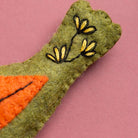 Textile art piece with embroidered flowers on a pink background