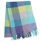 A folded woven scarf with a plaid pattern in shades of blue, teal, yellow, purple, and gray, finished with fringed edges, shown on a plain white background.