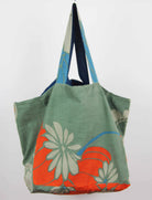 Green tote bag with floral design on a white background