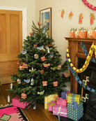 Decorated Christmas tree with ornaments and presents in a living room.