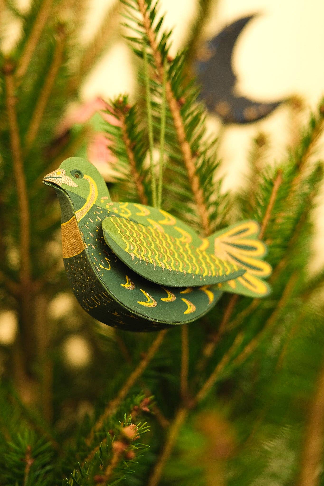 Decorative green and yellow bird ornament on a tree branch