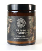 Candle labeled 'Fireside Nights' with pine cone design on a white background