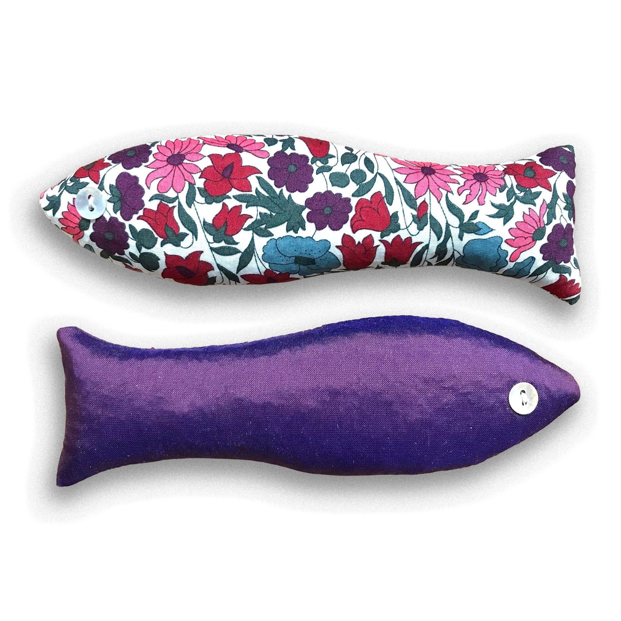 Floral-patterned and purple fish-shaped sachets on a white background
