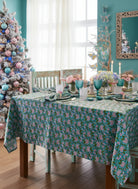 Dining room with a floral tablecloth, chairs, and decorative elements.