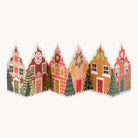 A concertina card made up of six colourful Christmas houses arranged in a row against a plain white background.