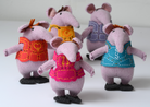 Five knitted mouse plush toys standing side by side, each wearing a different coloured vest. The vests are orange-red, yellow, pink, and blue, and the mice are made of light purple-pink knit fabric.