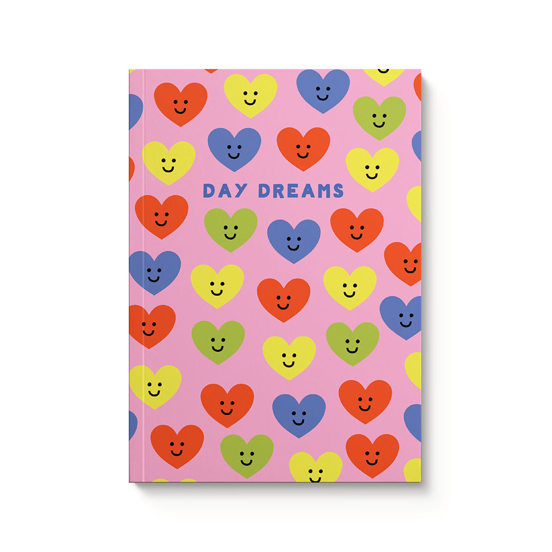 Notebook with colorful heart designs and 'Day Dreams' text on a pink background
