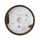 Round container with lid featuring nature-themed illustrations and text on a white background