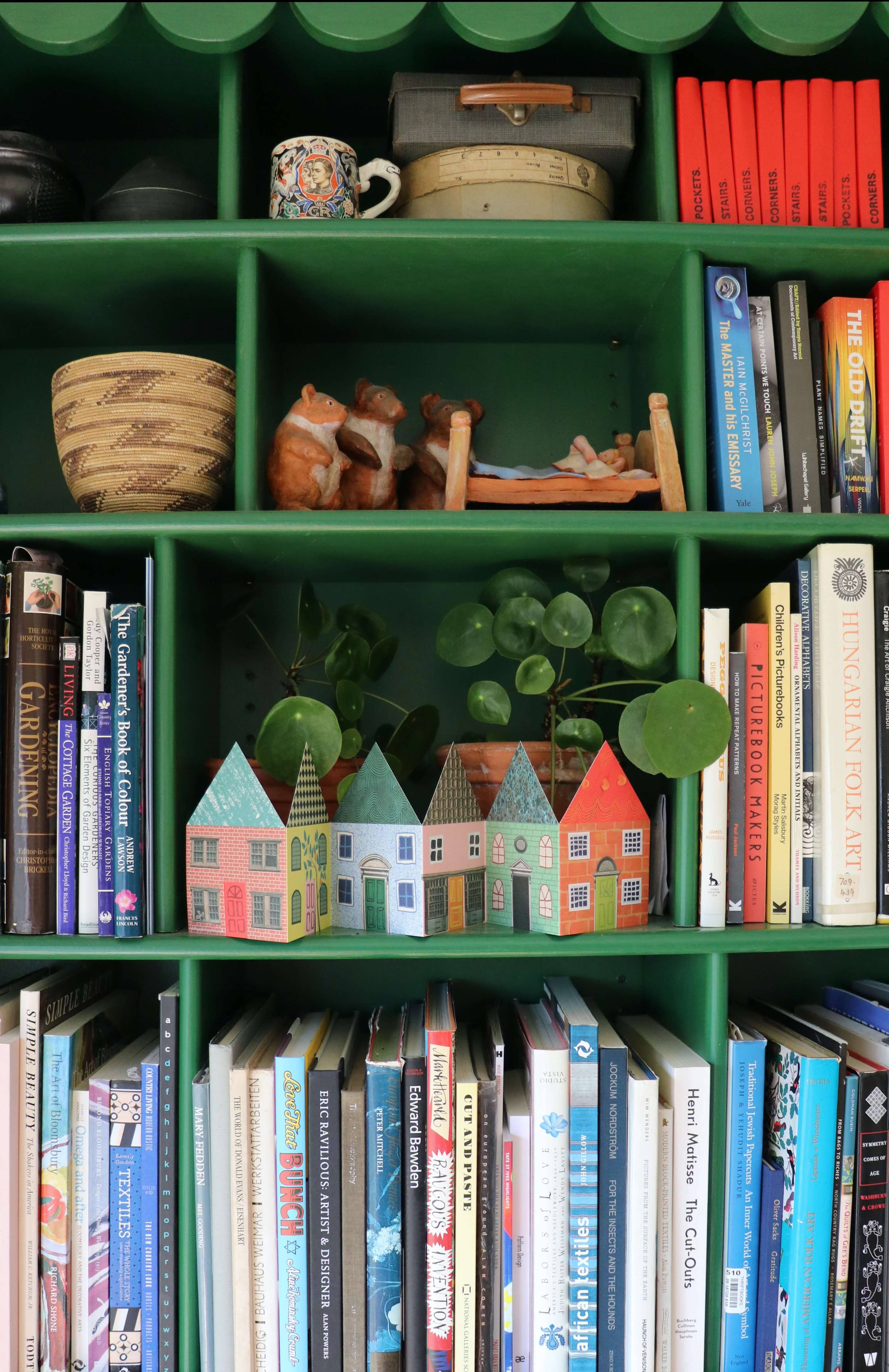 Bookshelf with books and decorative items on display including the houses concertina card