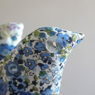 Blue floral fabric bird with floral pattern on a plain background