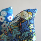 Decorative bird shaped lavender sachet with floral pattern and button eye on a neutral background